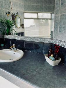 a bathroom with a sink and a mirror at La Grace Guestrooms in Kroonstad +19 photos