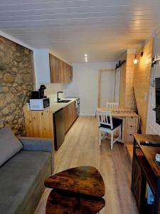 eine Küche und ein Wohnzimmer mit Sofa und Tisch in der Unterkunft Rustic ABAT 18 in Puigcerdà