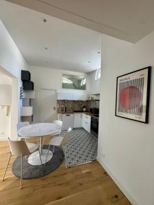 a kitchen with a table and chairs in a room at Maison Delayant in La Rochelle