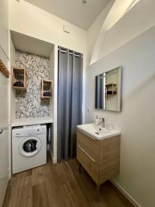 a bathroom with a washing machine and a sink at Maison Delayant in La Rochelle +3 photos