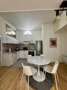 a kitchen with a table and chairs in a room at Maison Delayant in La Rochelle