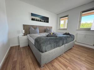 a bedroom with a large bed and two windows at Ferienwohnung BEST VIEW Brilon in Brilon