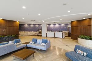 a lobby with blue couches and a table at Embassy Suites Buffalo in Buffalo