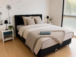 a bedroom with a large bed with a blue pillow on it at Stor 2 værelses lejlighed in Randers