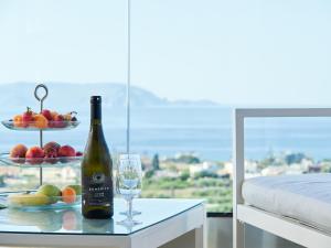 a bottle of wine and a plate of fruit on a table at Gaea Loft Villa - 1st Floor in Kokkini Khanion