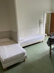two twin beds in a room with a mirror at Gîte de la cathédrale in Condom