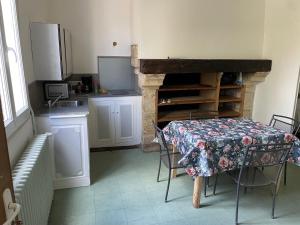 a kitchen with a table and a kitchen with a fireplace at Gîte de la cathédrale in Condom