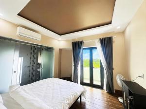 a bedroom with a bed and a large window at Victoria Hostel Huế in Hue