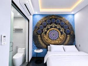 a bedroom with a bed and a painting on the wall at Victoria Hostel Huế in Hue +40 photos