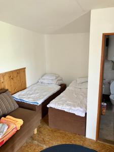 a room with two beds and a couch in it at Chaty u Toma Slapy in Nalžovice