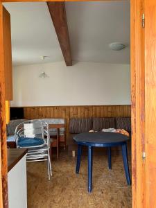 a room with a table and chairs and a couch at Chaty u Toma Slapy in Nalžovice +5 photos