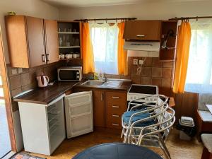 a small kitchen with a sink and a stove at Chaty u Toma Slapy in Nalžovice