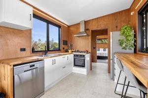 a kitchen with white cabinets and a wooden counter at Relaxing Getaway in Pohara in Pohara +19 photos