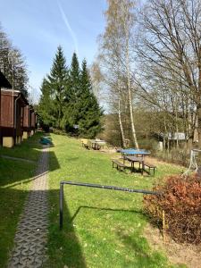 a park with benches and picnic tables in the grass at Chaty u Toma Slapy in Nalžovice