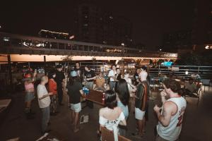 a group of people standing on a deck at night at F18 Hub Youth Hostel in Chengdu