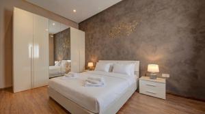 a bedroom with a large white bed and a mirror at Villa Goa - By Luxury Villas Malta in Mellieħa +44 photos