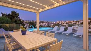 a patio with a table and chairs and a pool at Villa Goa - By Luxury Villas Malta in Mellieħa