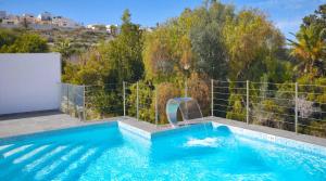 a swimming pool with a water slide in the middle at Villa Goa - By Luxury Villas Malta in Mellieħa