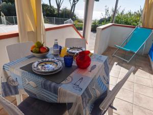 a table with a bowl of fruit on top of a balcony at Appartamenti Seccheto in Seccheto