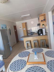 a room with a table and a kitchen at Hartenbos - Bayview 230m from beach in Mossel Bay