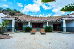 two chairs sitting in front of a house at Casa-Cueva El Pastor in Artenara