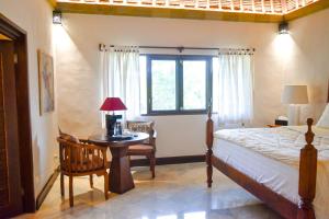 a bedroom with a bed and a table and a window at Villa Layangan - Two Bedrooms with Pool Access in Sanur +37 photos