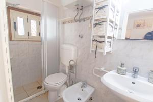 a white bathroom with a toilet and a sink at Appartamenti Seccheto in Seccheto