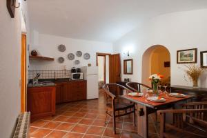 cocina y comedor con mesa y sillas en Casa-Cueva El Pastor, en Artenara