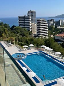 a swimming pool with chairs and umbrellas on a building at Status-M Apartments 112 in Bečići