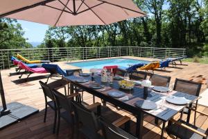 a table with chairs and an umbrella next to a swimming pool at Villa d'exception avec grande terrasse et piscine in Mons
