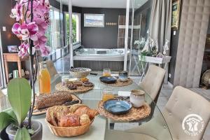 ein Tisch mit Brot und Körben voller Lebensmittel darauf in der Unterkunft La suite orchidée in Paimpol + 24 Fotos