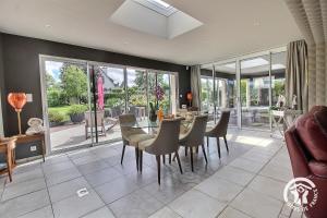 ein Esszimmer mit einem Glastisch und Stühlen in der Unterkunft La suite orchidée in Paimpol
