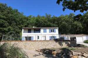 a white house on top of a stone wall at Villa d'exception avec grande terrasse et piscine in Mons