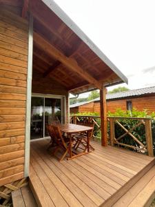 a wooden deck with a table and chairs on it at Chalet 4 personnes in Foix +8 photos