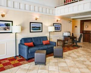 a living room with a blue couch and a desk at Comfort Inn Redding Near I-5 in Redding
