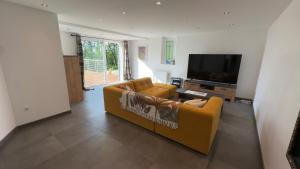 a living room with a couch and a flat screen tv at Villa d'exception avec grande terrasse et piscine in Mons