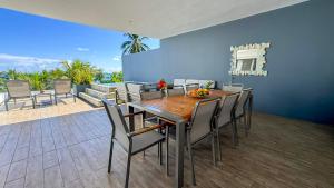 a dining room with a wooden table and chairs at Latitude By Horizon Holidays in Rivière Noire