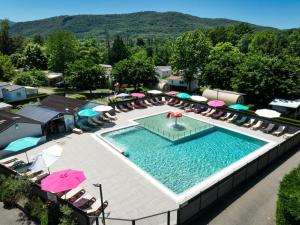 an overhead view of a swimming pool with chairs and umbrellas at Chalet 4 personnes in Foix