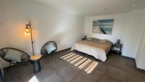 a bedroom with a bed and a table and chairs at Villa d'exception avec grande terrasse et piscine in Mons +20 photos