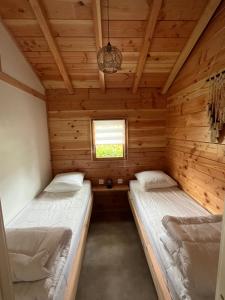 two beds in a log cabin with a window at Chalet 4 personnes in Foix