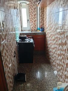 a small kitchen with a stove and a sink at Palace Ndogbong Bifaga in Bassa