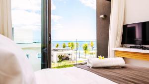 a bedroom with a large window with a view of the ocean at Latitude By Horizon Holidays in Rivière Noire
