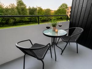 a table and two chairs on a balcony with wine glasses at Stor 2 værelses lejlighed in Randers +11 photos