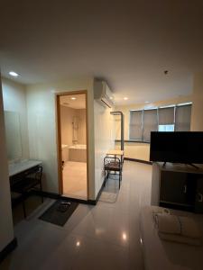a living room with a couch and a table and a bathroom at Nice Hotel Monumento in Manila