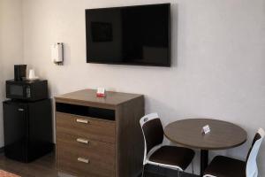 a room with a table and a tv on a wall at Econo Lodge Calhoun South in Calhoun +9 photos