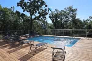 a swimming pool with tables and chairs on a wooden deck at Villa d'exception avec grande terrasse et piscine in Mons