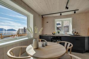 a kitchen with a table and chairs and a window at Arctic Nest in Nyksund