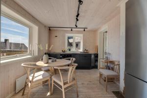a kitchen and dining room with a table and chairs at Arctic Nest in Nyksund +34 photos