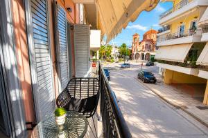a balcony with a bench and a table and a street at Chrysiida Luxury Apt, Stroll to Nafplio Center in Nafplio