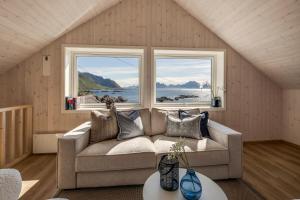 a living room with a couch and two windows at Arctic Nest in Nyksund